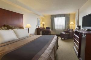 リッチモンドにあるTravelodge Hotel by Wyndham Vancouver Airportのベッドと薄型テレビがあるホテルの部屋