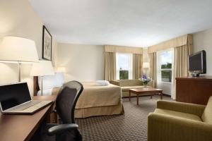 a hotel room with a bed and a desk with a laptop at Quality Inn in North Bay