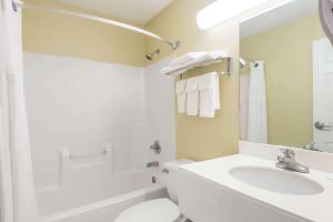 Super 8 by Wyndham Indianapolis/NE/Castleton Area في انديانابوليس: حمام أبيض مع حوض ومرحاض