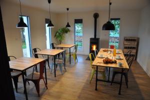 a dining room with tables and chairs and windows at L'Atelier in Sainte-Marie-du-Lac-Nuisement 