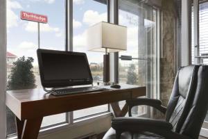un ordenador portátil sentado en un escritorio junto a una silla en Thriftlodge Saskatoon, en Saskatoon