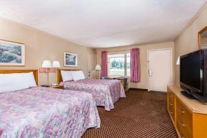 a hotel room with two beds and a flat screen tv at Travelodge by Wyndham Ridgeway Martinsville Area in Martinsville