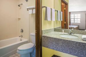 a bathroom with a toilet and a sink and a tub at Super 8 by Wyndham Cabot in Cabot