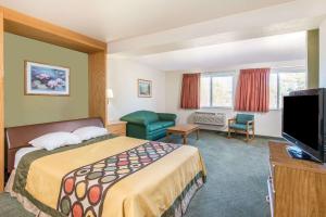 a hotel room with a bed and a flat screen tv at Super 8 by Wyndham West Middlesex/Sharon Area in West Middlesex