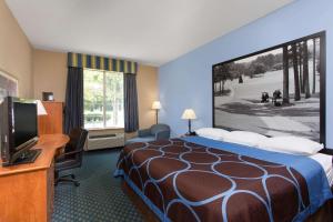 A bed or beds in a room at Super 8 by Wyndham Smithfield-Selma