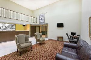 a waiting room with a couch and chairs and a tv at Super 8 by Wyndham Dawsonville in Dawsonville