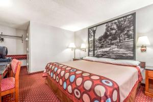 a hotel room with a bed with a large painting on the wall at Super 8 by Wyndham North Bergen NJ/NYC Area in North Bergen