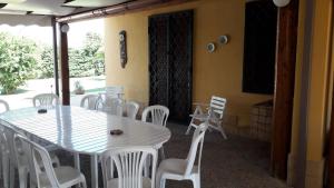 a dining room with a table and white chairs at Villa Margherita in Marsala