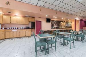 a restaurant with tables and chairs and a bar at Castle Inn & Suites in Lawton
