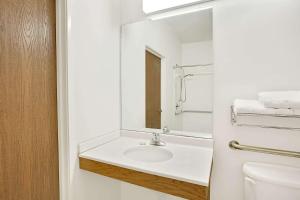 a white bathroom with a sink and a mirror at Super 8 by Wyndham Hampshire IL in Hampshire