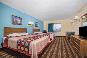 a hotel room with two beds and a flat screen tv at Super 8 by Wyndham Osseo WI in Osseo