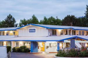 a large building with a blue roof at Travelodge by Wyndham Grants Pass in Grants Pass