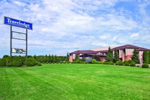 una señal en un campo frente a un edificio en Travelodge by Wyndham Motel of St Cloud, en Saint Cloud