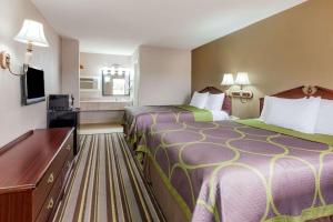 een hotelkamer met 2 bedden en een flatscreen-tv bij Super 8 by Wyndham Mt. Pleasant TX in Mount Pleasant