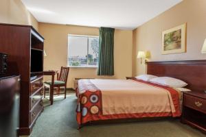 a hotel room with a bed and a desk and a window at Super 8 by Wyndham Dixon/UC Davis in Dixon