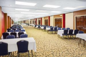 a room with rows of tables and blue chairs at Howard Johnson by Wyndham Williamsburg in Williamsburg