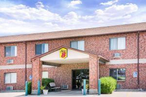 a red brick building with a sign in front of it at Super 8 by Wyndham Chanute in Chanute