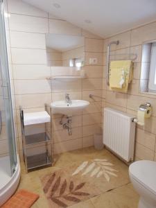 a bathroom with a toilet, sink, tub and shower stall at Rooms-Apartments Stojanovič in Bled