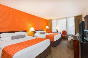 a hotel room with two beds and a flat screen tv at Howard Johnson by Wyndham Williamsburg in Williamsburg +21 photos