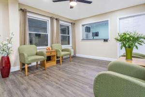 a waiting room with chairs and a table and windows at Super 8 by Wyndham Manning in Manning