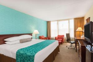 um quarto de hotel com uma cama grande e uma televisão em Howard Johnson by Wyndham Williamsburg em Williamsburg