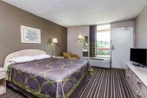 una camera d'albergo con letto e TV di Super 8 by Wyndham Commerce a Commerce