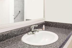 a bathroom counter with a sink and a mirror at Travelodge by Wyndham Shreveport LA in Shreveport