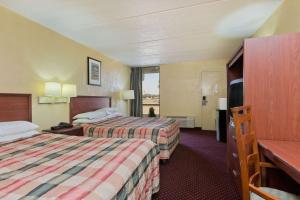 a hotel room with two beds and a television at Knights Inn Brenham in Brenham
