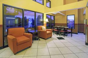 a lobby with chairs and a table and a dining room at Super 8 by Wyndham Denver Stapleton in Denver