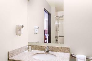a bathroom with a sink and a mirror at Super 8 by Wyndham Wheeling Saint Clairsville OH Area in Wheeling