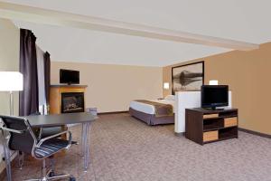 LebanonにあるSuper 8 by Wyndham Lebanonのベッドと机とテレビがあるホテルの部屋