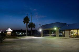 een parkeerplaats voor een gebouw 's nachts bij Knights Inn Brenham in Brenham