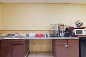 a kitchen counter with a sink and a microwave at Knights Inn Brenham in Brenham