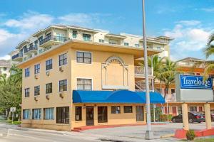 - un bâtiment dans une rue avec un panneau devant dans l'établissement Travelodge by Wyndham Fort Lauderdale, à Fort Lauderdale