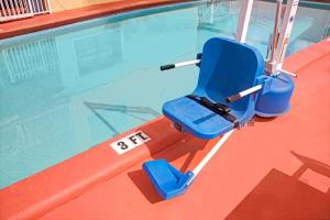 una silla azul sentada junto a una piscina en Travelodge by Wyndham Fort Lauderdale, en Fort Lauderdale
