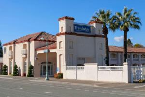 un edificio con un cartel en una calle en Travelodge by Wyndham Redding CA, en Redding