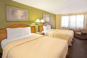 A bed or beds in a room at Travelodge by Wyndham Fort Lauderdale