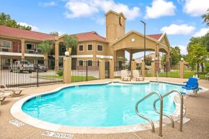a large swimming pool in front of a building at Super 8 by Wyndham Houston/Brookhollow NW in Houston