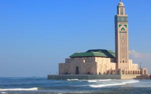 un bâtiment avec une tour d'horloge sur la plage dans l'établissement Casablanca Home Stay Apartment, à Casablanca