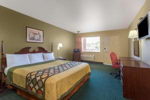 a hotel room with a bed and a desk and a television at Super 8 by Wyndham Durham/University Area NC in Durham