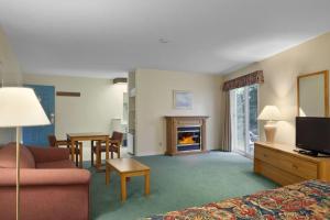 Habitación de hotel con sofá y chimenea en Travelodge by Wyndham Bracebridge, en Bracebridge