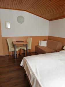 a bedroom with a bed, chair, table and a lamp at Rooms-Apartments Stojanovič in Bled