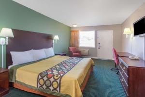 a hotel room with a large bed and a desk at Super 8 by Wyndham Durham/University Area NC in Durham