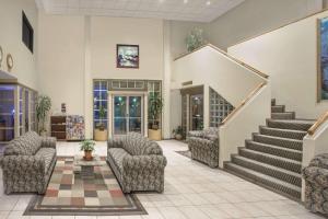 a lobby with chairs and stairs in a building at Knights Inn Pico Rivera in Pico Rivera