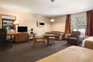 a hotel room with a bed and a desk and a room at Super 8 by Wyndham North Bay in North Bay