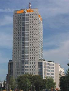 wysoki budynek z znakiem na górze w obiekcie Warsaw Apartments Werset w Warszawie