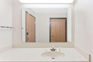 a bathroom with a sink and a mirror at Super 8 by Wyndham Cloverdale IN in Cloverdale +4 photos