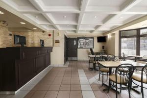 a dining room with tables and chairs and a tv at Super 8 by Wyndham North Bay in North Bay