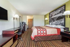 a hotel room with a bed and a flat screen tv at Super 8 by Wyndham Cloverdale IN in Cloverdale