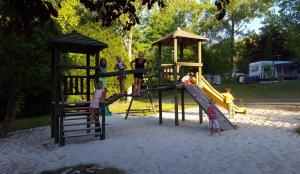 a group of children playing on a playground at Le Verdoyant in Thenon